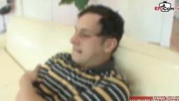 Mann mit Brille liegt entspannt auf heller Couch und schaut erwartungsvoll zur Seite